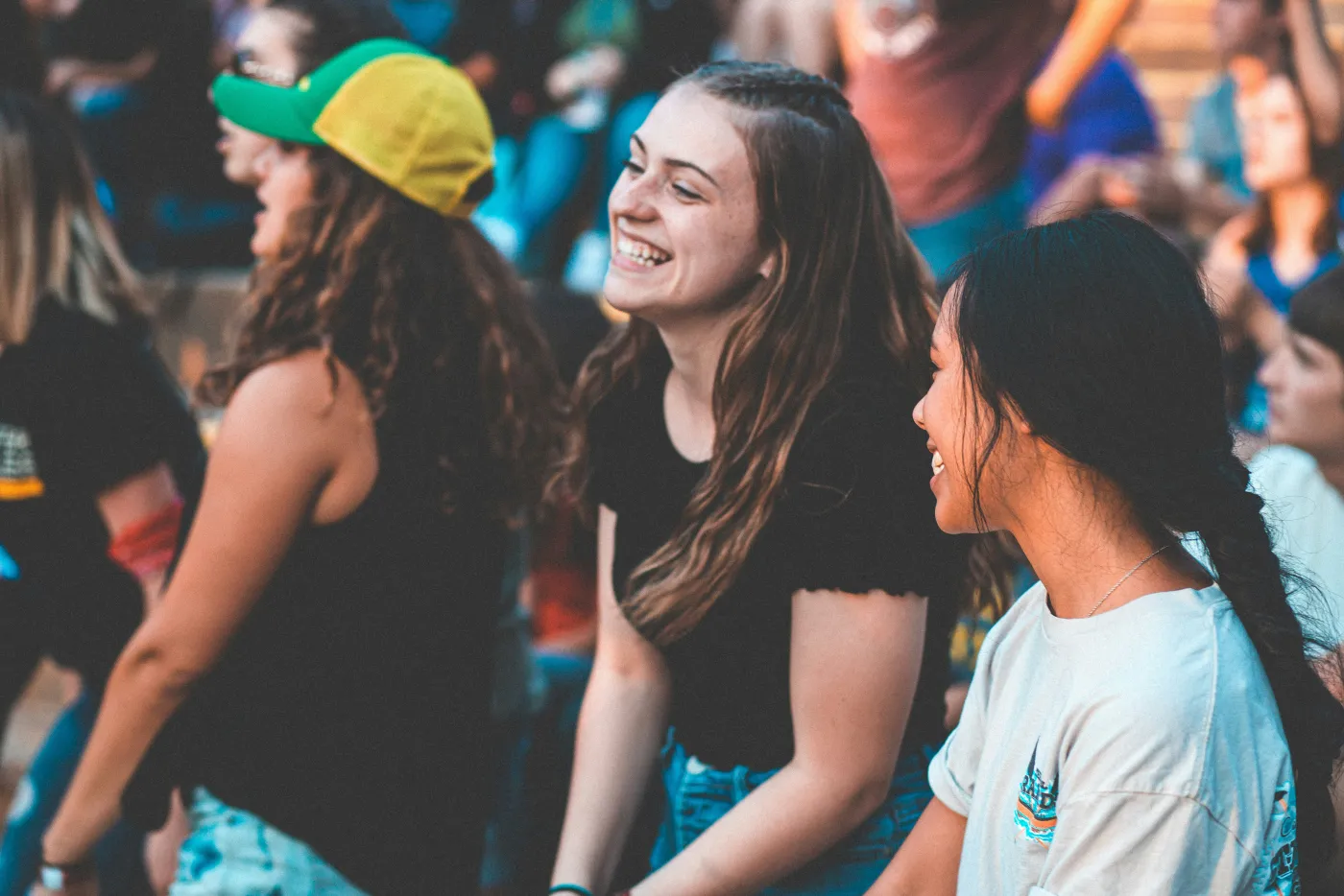 A group of teenage girls laughing together in a crowd