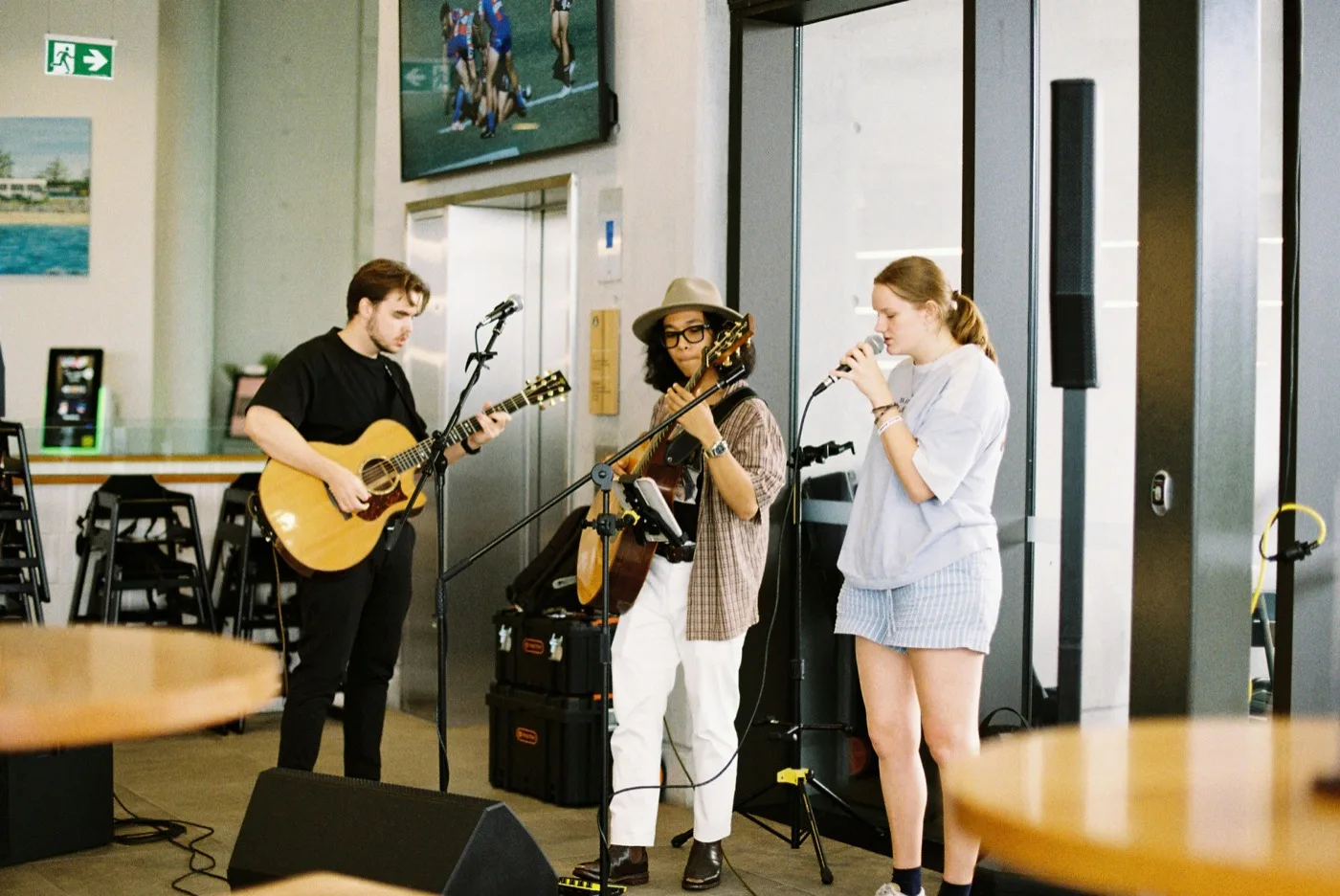 Three young musicians performing together — acoustic guitar, electric guitar and vocals